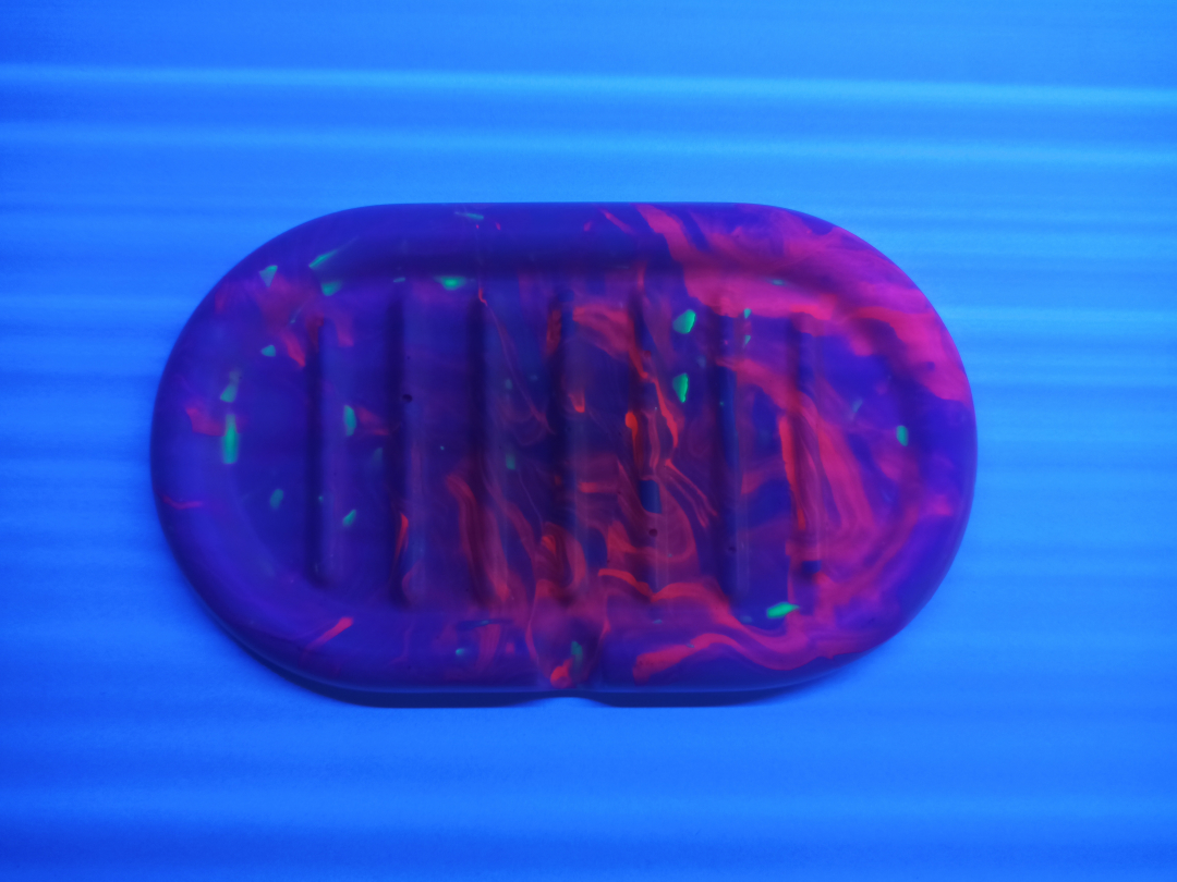 éclairage à la lampe UV d'un porte-savon fabriqué en Jesmonite de couleur rose fluorescent terrazzo vert fluo