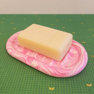 mise en situation avec un savon d'un porte-savon fabriqué en Jesmonite de couleur rose fluo marbré