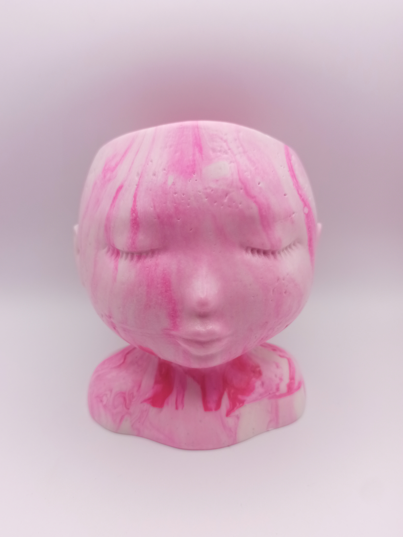 pot en forme de visage aux traits fins et délicats fabriqué en Jesmonite couleur rose fluorescent marbré