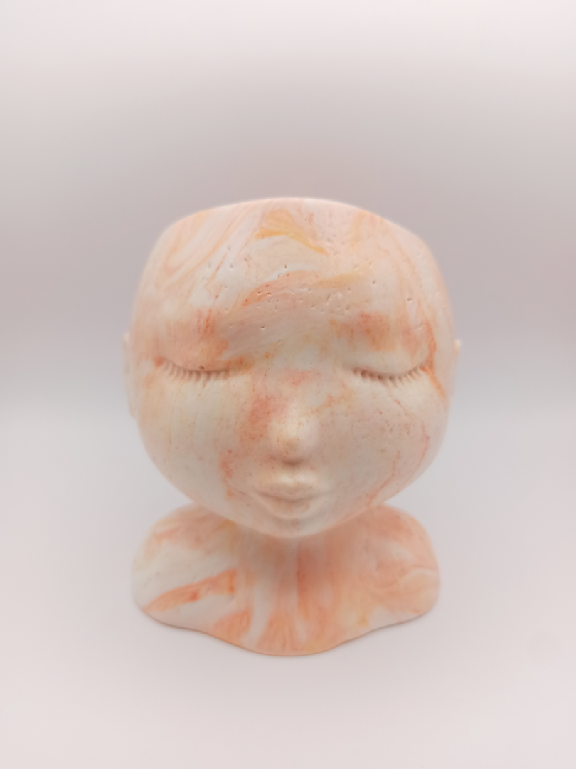 pot en forme de visage aux traits fins et délicats fabriqué en Jesmonite couleur orange marbré