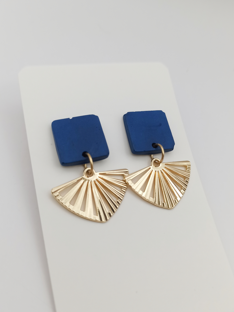 boucles d'oreilles courtes puces carrés en Jesmonite de couleur bleu foncé avec un pendentif éventail ajouré en acier inoxydable doré