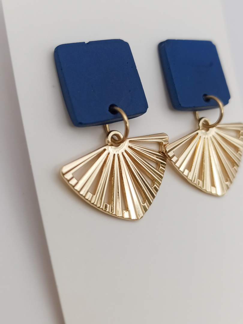 boucles d'oreilles courtes puces carrés en Jesmonite de couleur bleu foncé avec un pendentif éventail ajouré en acier inoxydable doré