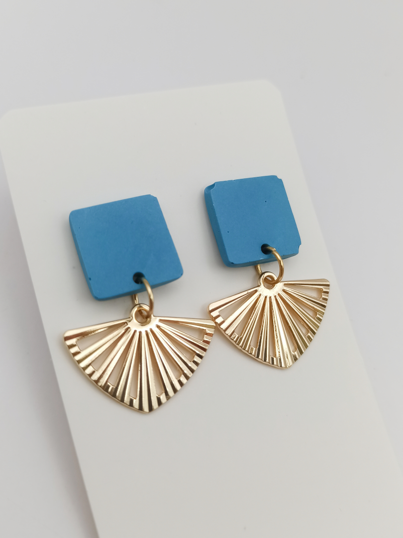 boucles d'oreilles courtes puces carrés en Jesmonite de couleur bleu clair avec un pendentif éventail ajouré en acier inoxydable doré